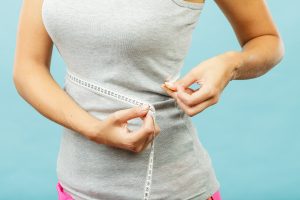 Slim woman measuring waistline